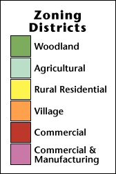 Zoning districts: woodland (green), agricultural (light green), rural residential (yellow), village (orange), commercial (red), commercial and manufacturing (pink).