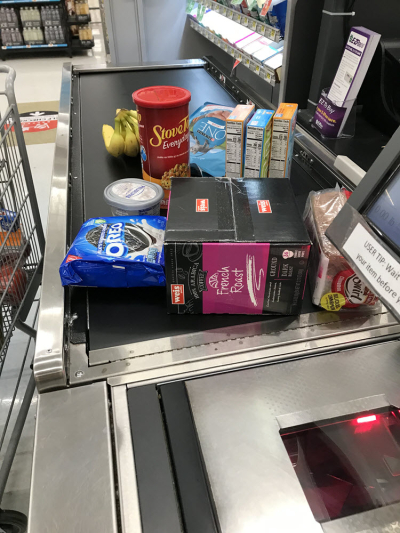 conveyor belt at grocery store with  food piling up.