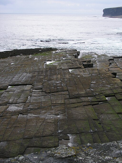 Rock with joints running vertical and intersecting at right angles. It almost looks like bricks.