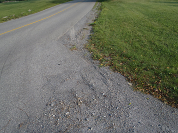 Road with driveway in the foreground. See description below