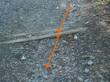 Steep slope gravel road with wodden boards placed across the road.