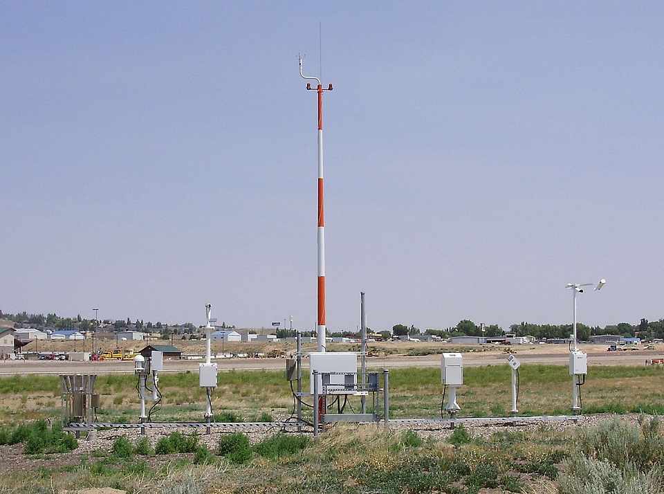 A collection of weather instruments alongside of a runway