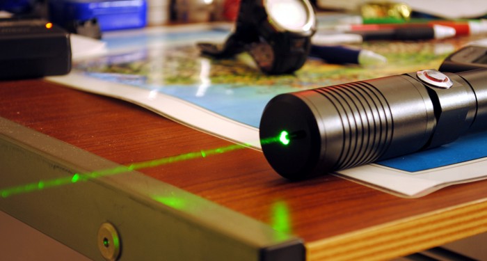 Photograph of pocket laser with the beam visible because of dust in the air.